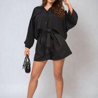 Black high-waist paper bag tie shorts with waist tie and gathered front.
