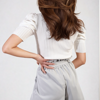 Grey high-waist paper bag shorts with tie belt at the waist and side pockets