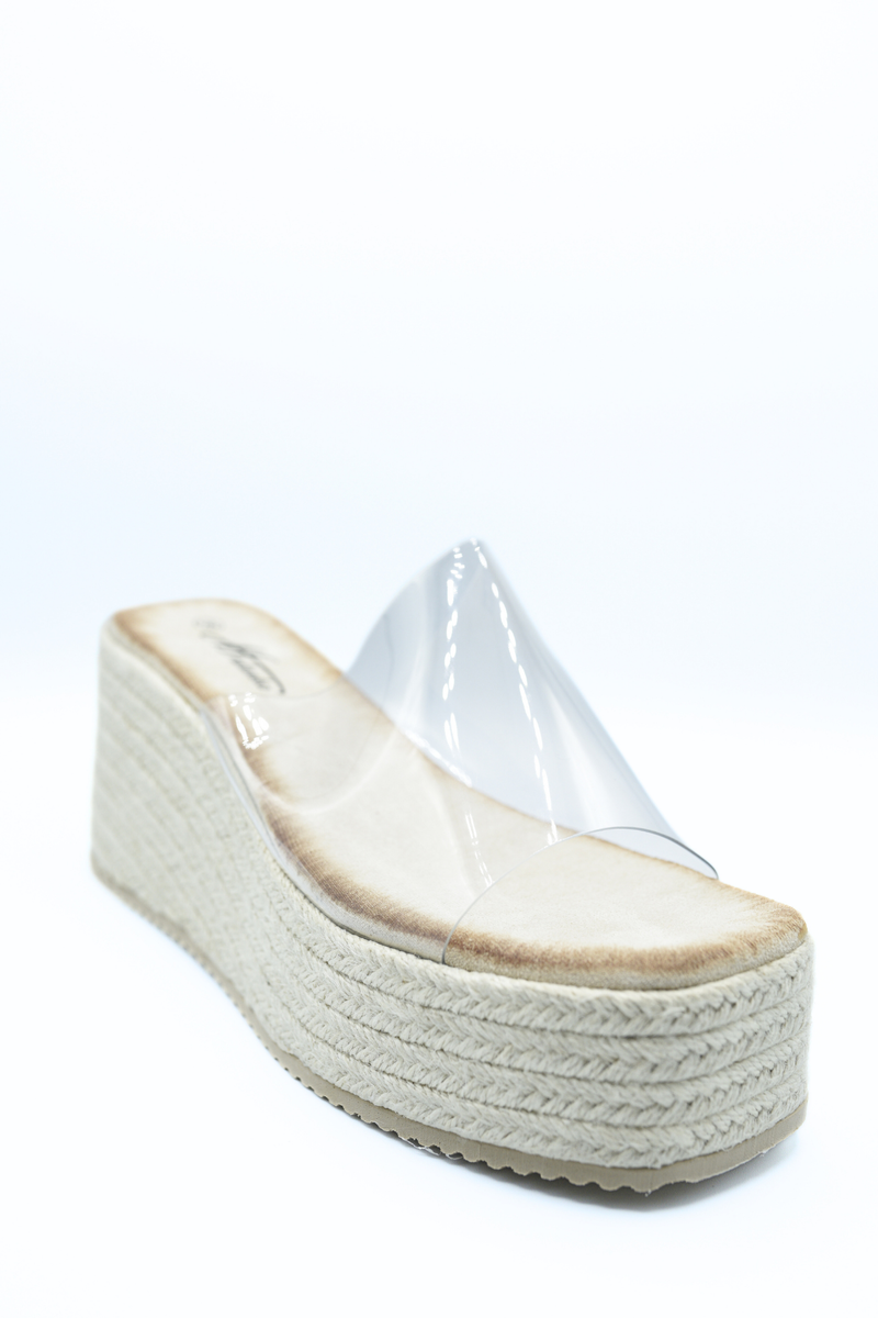 Beige platform wedge slide sandals with clear upper and espadrille-textured midsole