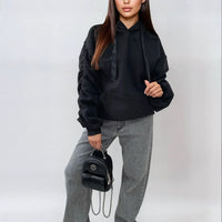 Oversized black hoodie with ruched sleeves, front pouch pocket, and drawstring hood