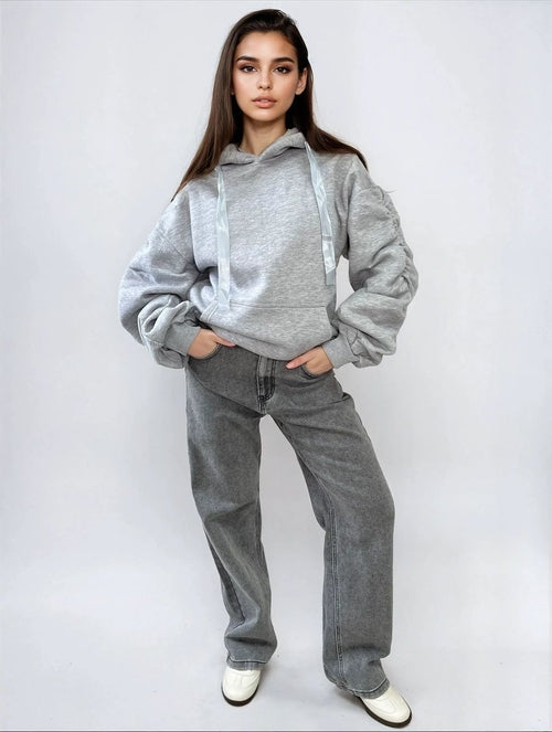 Light gray oversized hoodie with drawstring hood, front pouch pocket, and ruched sleeves