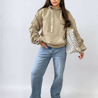 Oversized beige hoodie with ruched sleeves, pouch pocket, and drawstring hood