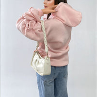 Oversized pink hoodie with ruched sleeves, front pouch pocket, and drawstring hood