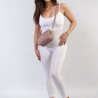 Fitted white scoop-neck jumpsuit with slim straps, standing three-quarter view