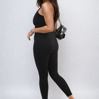 Black bodycon jumpsuit with scoop neck and slim straps, fitted long leggings legs