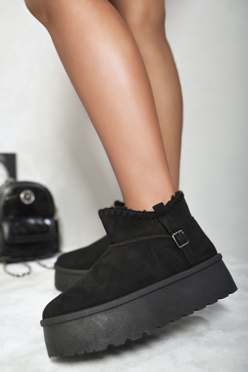 Black suede ankle boots with faux fur lining, side buckle strap, and chunky platform sole.