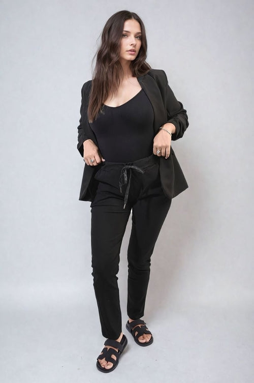 Black drawstring tapered trousers with side pockets, full body