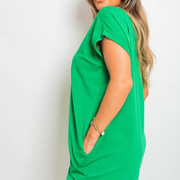Bright green short-sleeve tunic top with front pockets, loose silhouette.