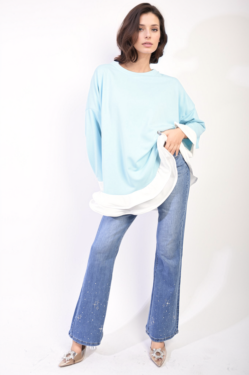 Oversized long-sleeve top in light blue with contrast ruffle hem and loose fit