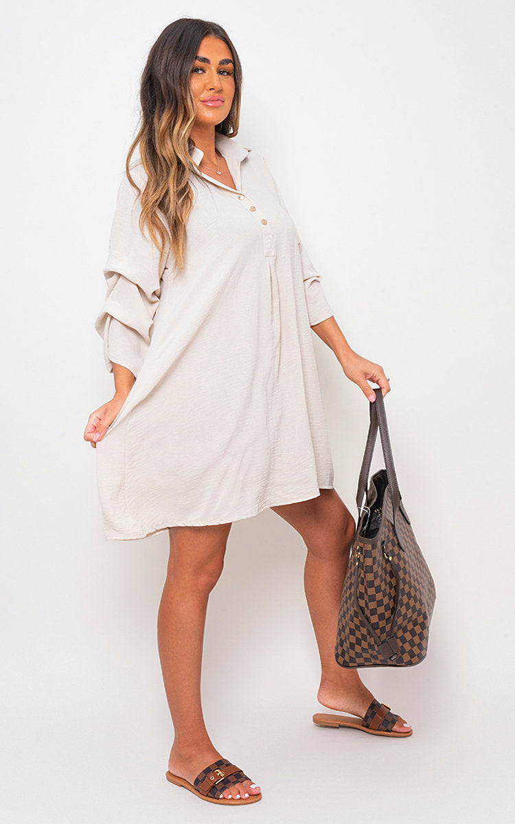 White shirt dress with collar, button front, and loose three-quarter sleeves.