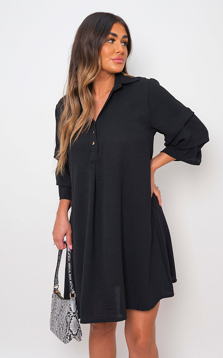 Black shirt dress with collar and loose sleeves, button front, side pose