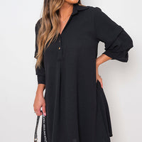 Black shirt dress with collar and loose sleeves, button front, side pose