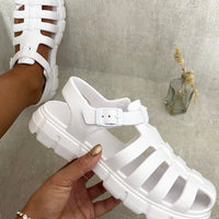 White chunky platform sandals with round open toe and adjustable buckled strap