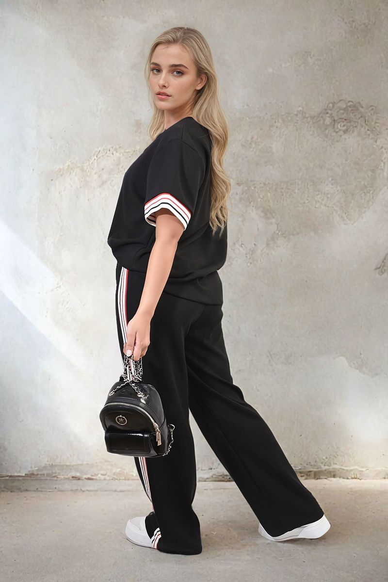 Black co-ord set with short-sleeve top and wide-leg trousers, striped sleeve and side trims