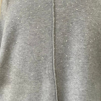 Close-up of grey knitted fabric with rhinestone speckle detail