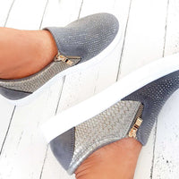 Grey slip-on trainer with rhinestone-dotted upper, croc-effect side panel, gold zip tab.