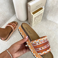 Platform slide sandals with orange woven straps and multicolor braided trim, open toe