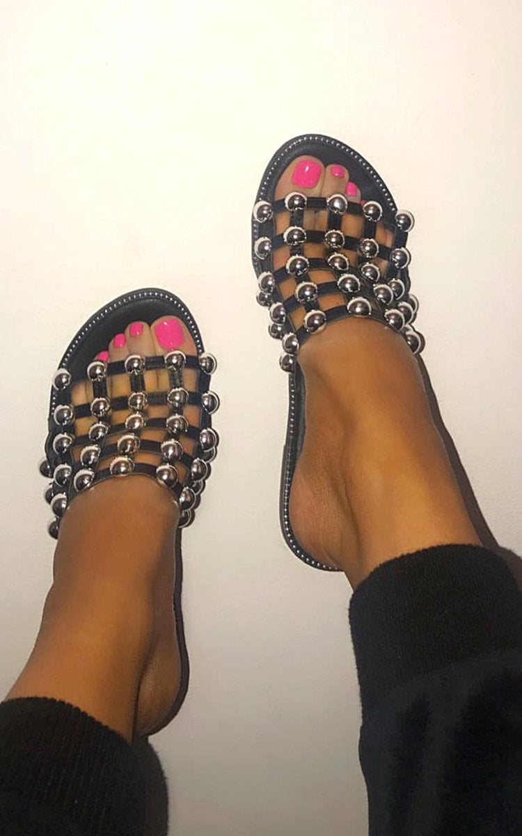 Black flat slides with gold-tone studded lattice straps and open toe