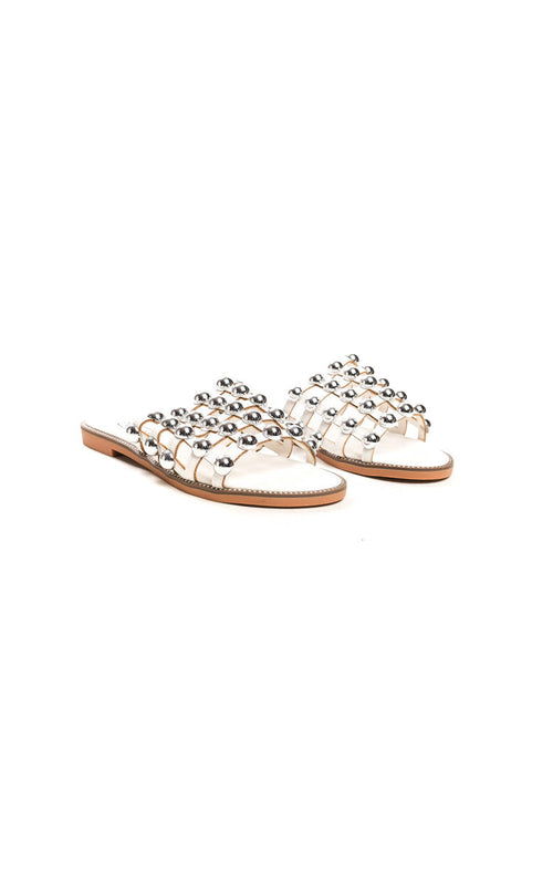 White flat slide sandals with studded lattice straps and open toe