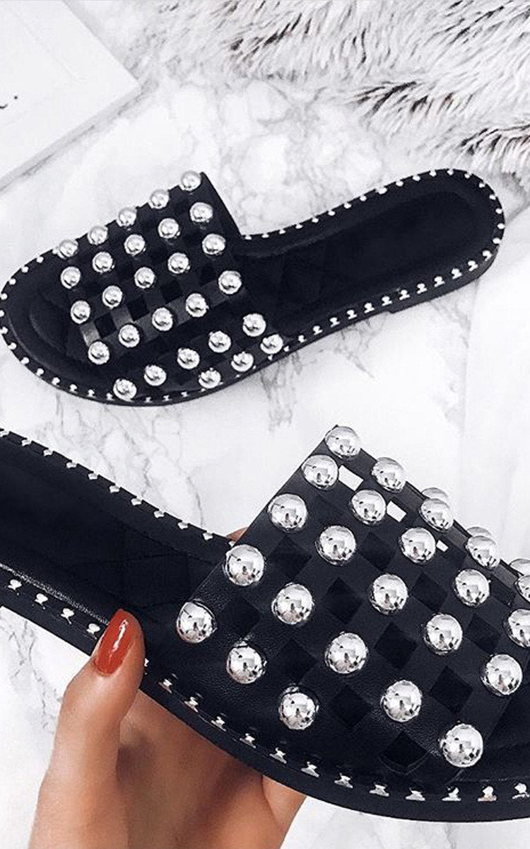 Black flat slides with silver studded lattice straps and scalloped stud trim