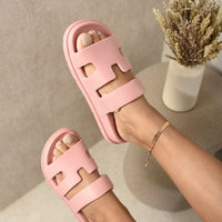 Pink slide sandals with wide geometric straps and open toe