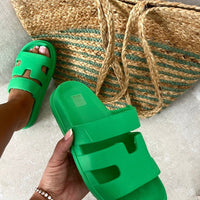 Green slide sandals with chunky sole and geometric cutout straps