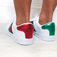 White trainers showing red and green heel panels, low-top lace-up design