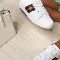 White lace-up trainers with colorful side panel, worn with light green pants