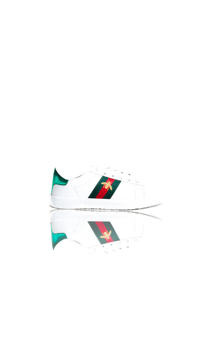 White trainers with green and red side patch, angled with mirrored view