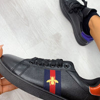 Black trainers with striped side patch and bee emblem, lace-up design