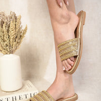 Gold-tone flat slide sandals with wide rhinestone straps and open toe