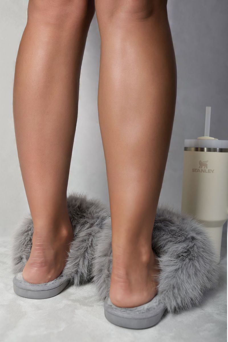 Light gray faux fur slide sandals with cushioned sole, worn by legs