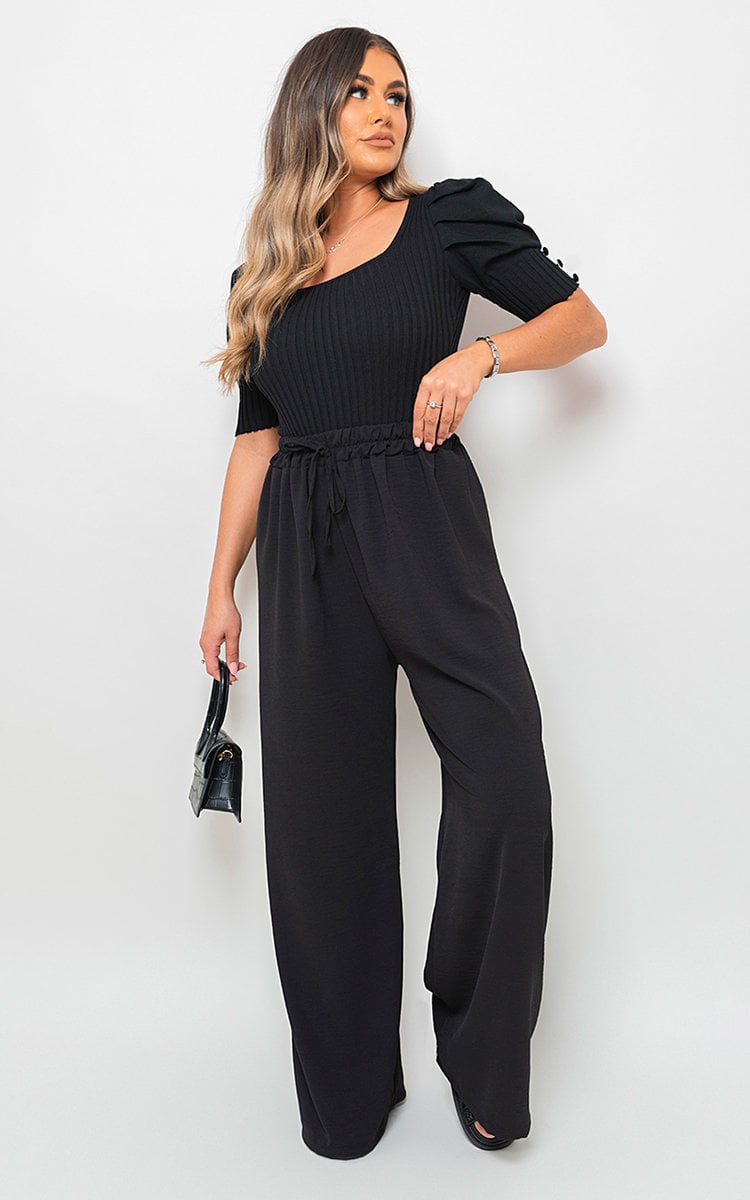 Black wide-leg trousers with gathered drawstring waist, full-body side view