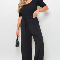 Black wide-leg trousers with gathered drawstring waist, full-body side view