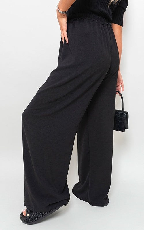 Black wide-leg trousers with drawstring gathered waist and roomy, draped legs