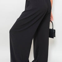 Black wide-leg trousers with drawstring gathered waist and roomy, draped legs