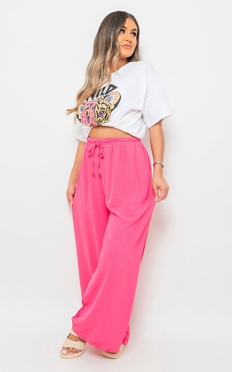 Fuchsia pink wide-leg trousers with gathered drawstring waist, side view