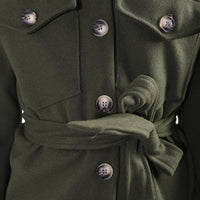 Olive green belted jacket close-up with dark buttons and tie waist.