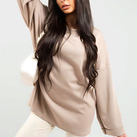 Oversized beige sweatshirt with round neck and long sleeves, relaxed drape.