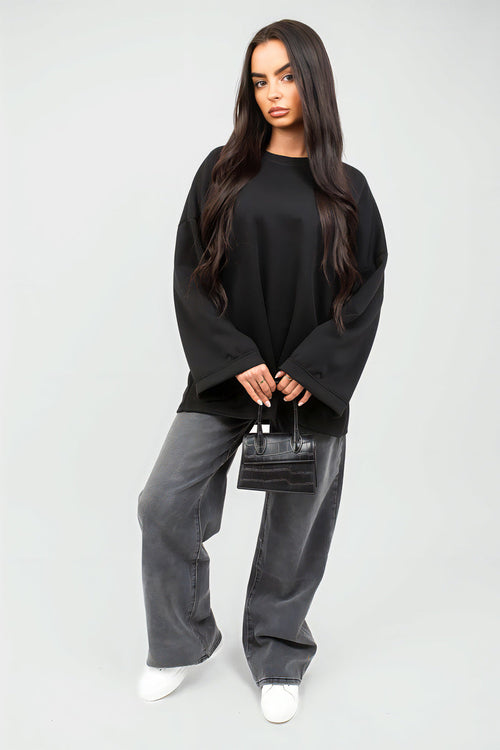 Oversized black sweatshirt with round neck and long sleeves, loose fit with cuffs.