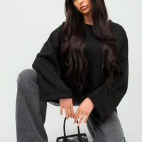 Oversized black sweatshirt with round neck and long sleeves, relaxed drape.