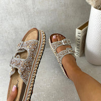 Embellished gold rhinestone platform sandals with double buckle straps and open toe.