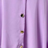 Oversized collared button-down top in lavender with gold round buttons, front placket close-up.