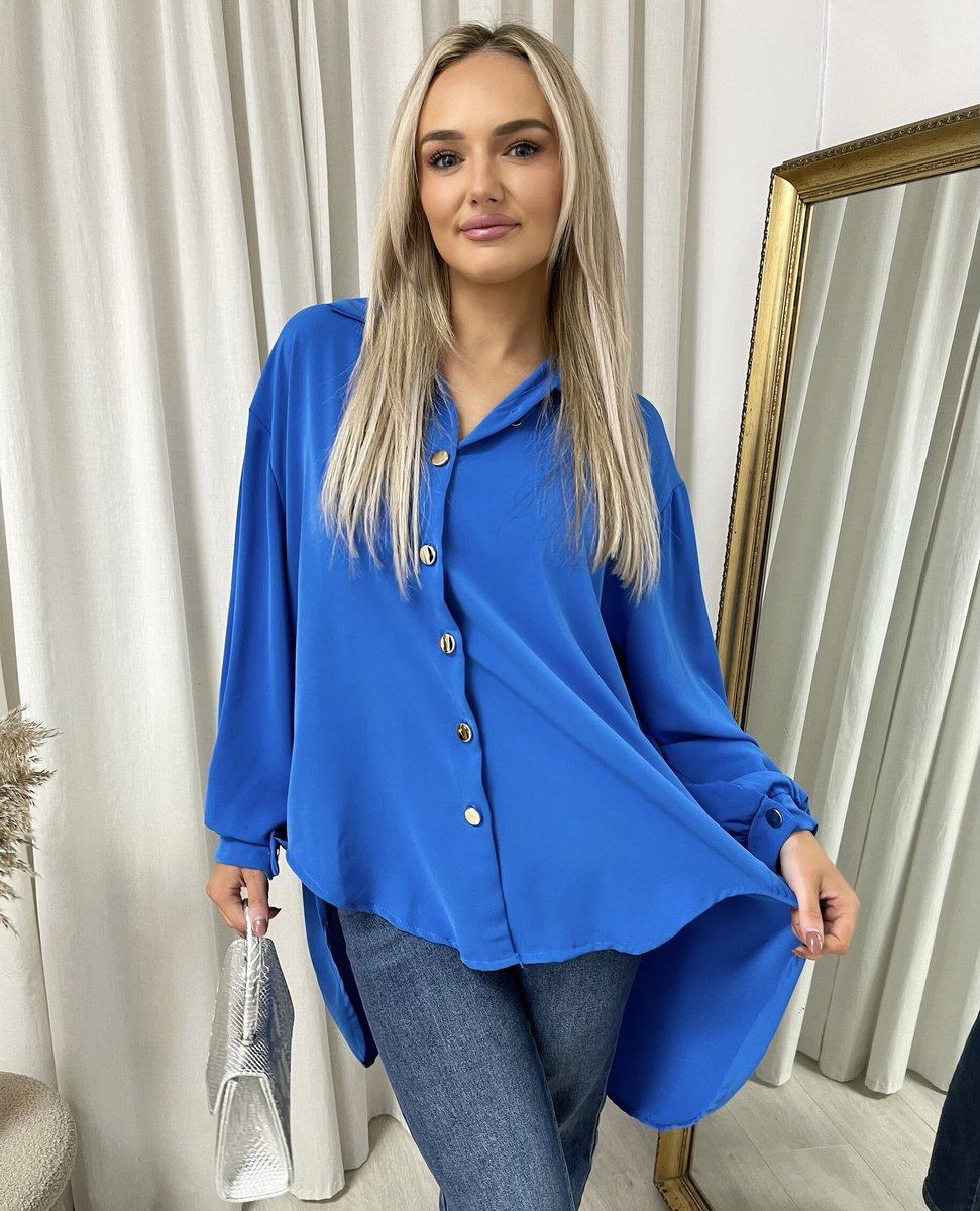 Oversized collared button-down top in bright royal blue with gold buttons and long sleeves.