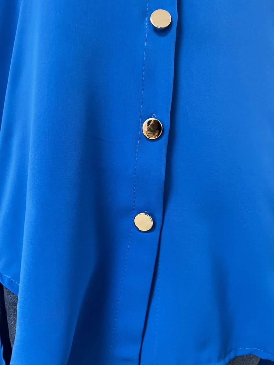 Royal blue button-down top close-up with collar seam and round front buttons