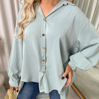 Light blue collared button-down top close-up with front buttons and gathered cuffs