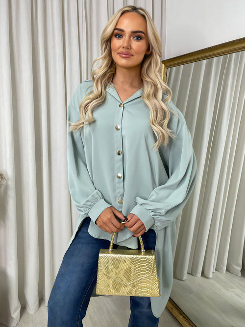 Oversized light-blue button-down blouse with pointed collar, long sleeves, front buttons