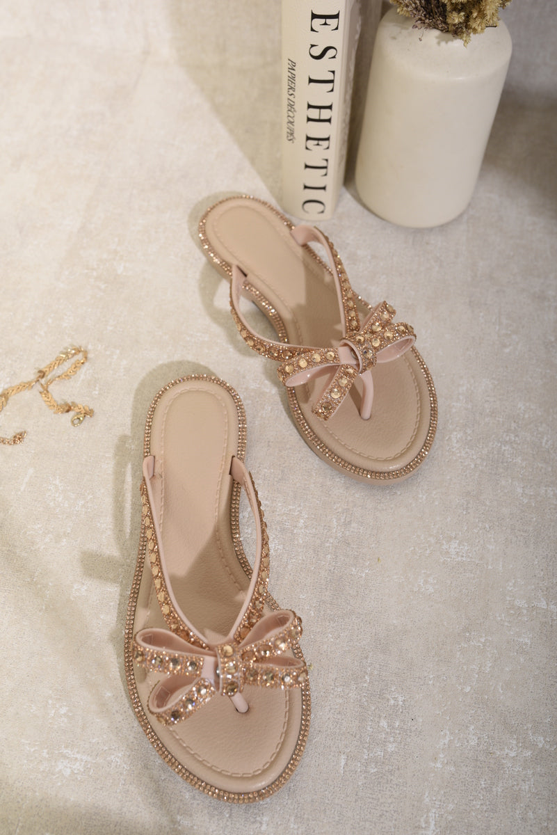Nude flat thong sandals with rhinestone bow, decorative edge trim, toe post