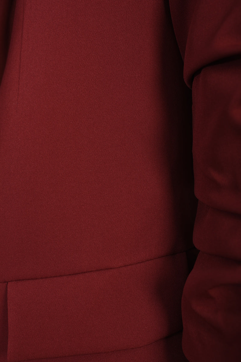 Wine red blazer fabric close-up with seam and ruched sleeve panel