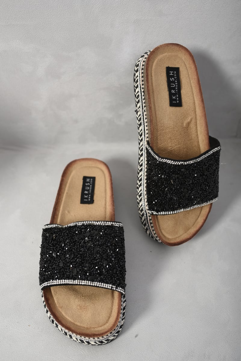 Black glitter platform slide sandals with white braided trim and tan insole